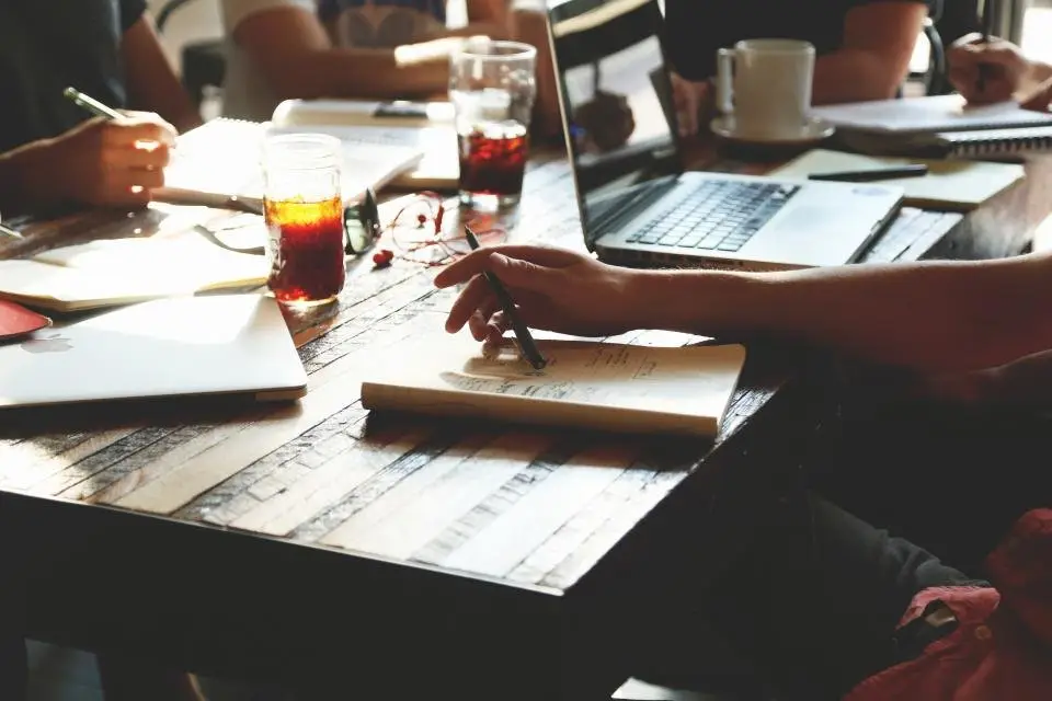 Team working together with laptops around a table, representing growth company funding